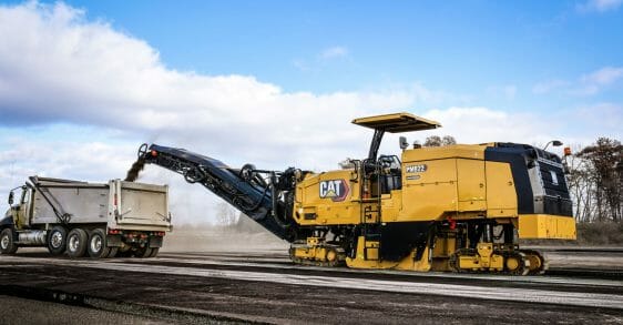 Large Cat machine dumping a load into the back of a dump truck