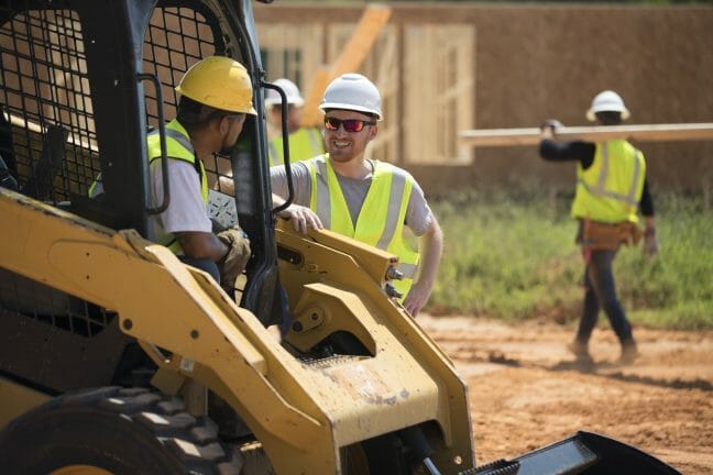 three men in hard hats at an outdoor worksite