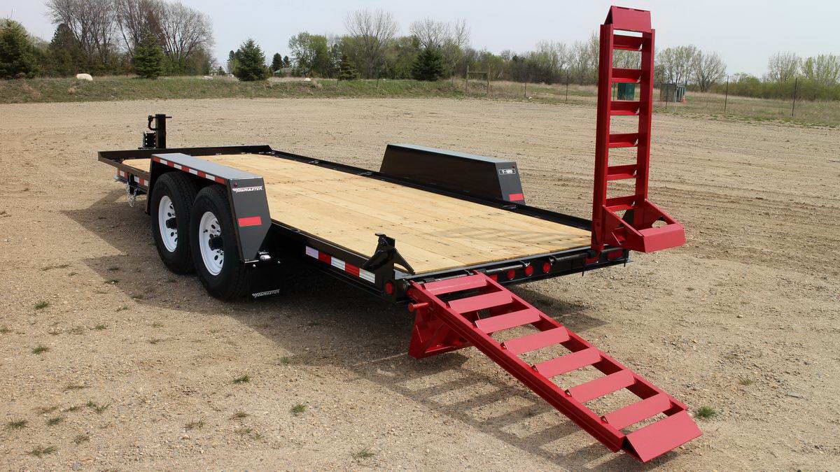 towmaster trailer in a gravel lot with one of the ramps lifted up