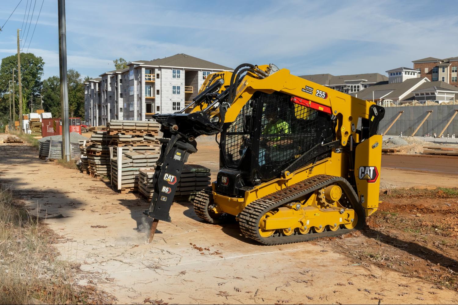 CAT skid steer with drill bit attachment at a job site 