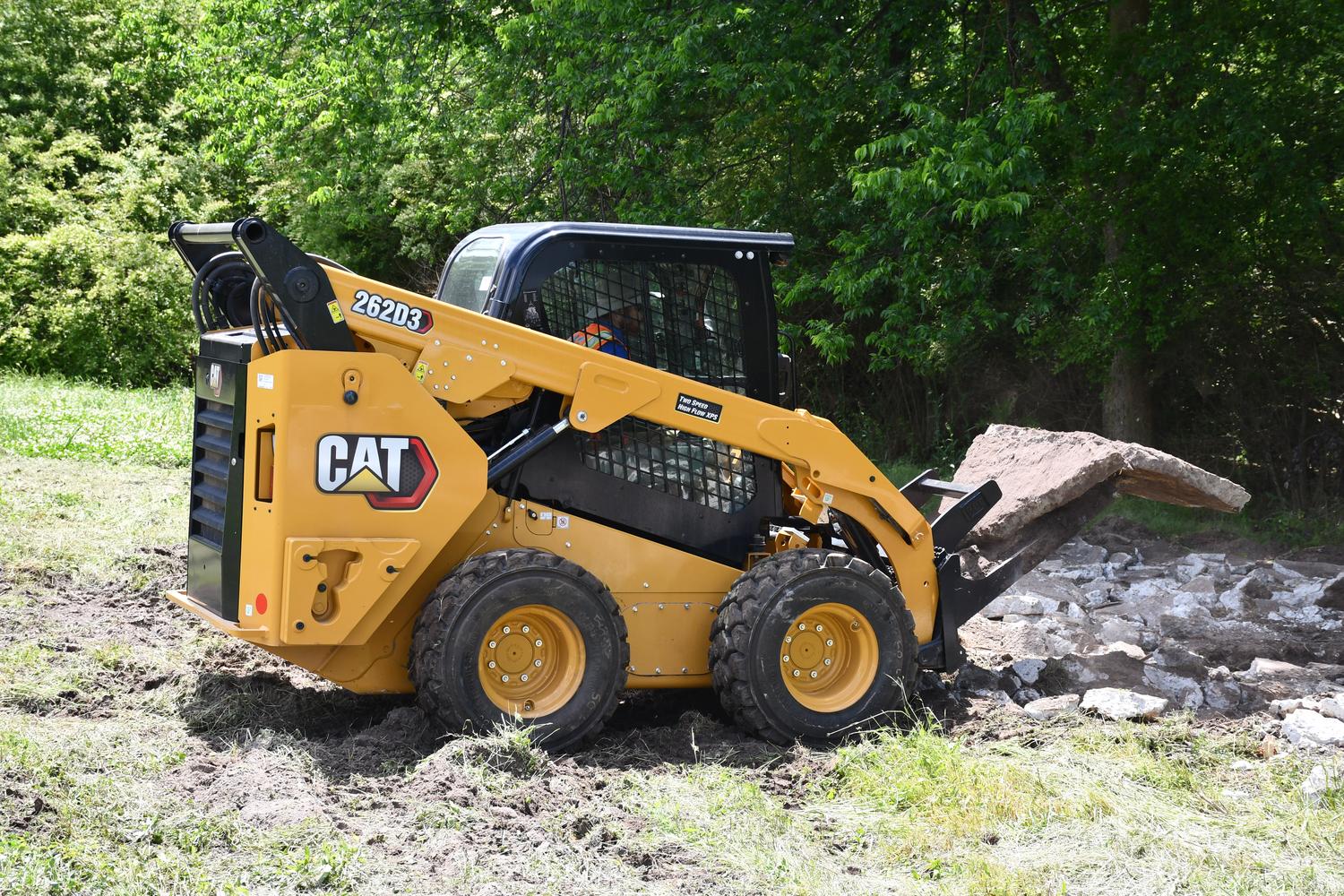CAT-rental-machine-with-tracks Rented CAT skid steer moving boulders