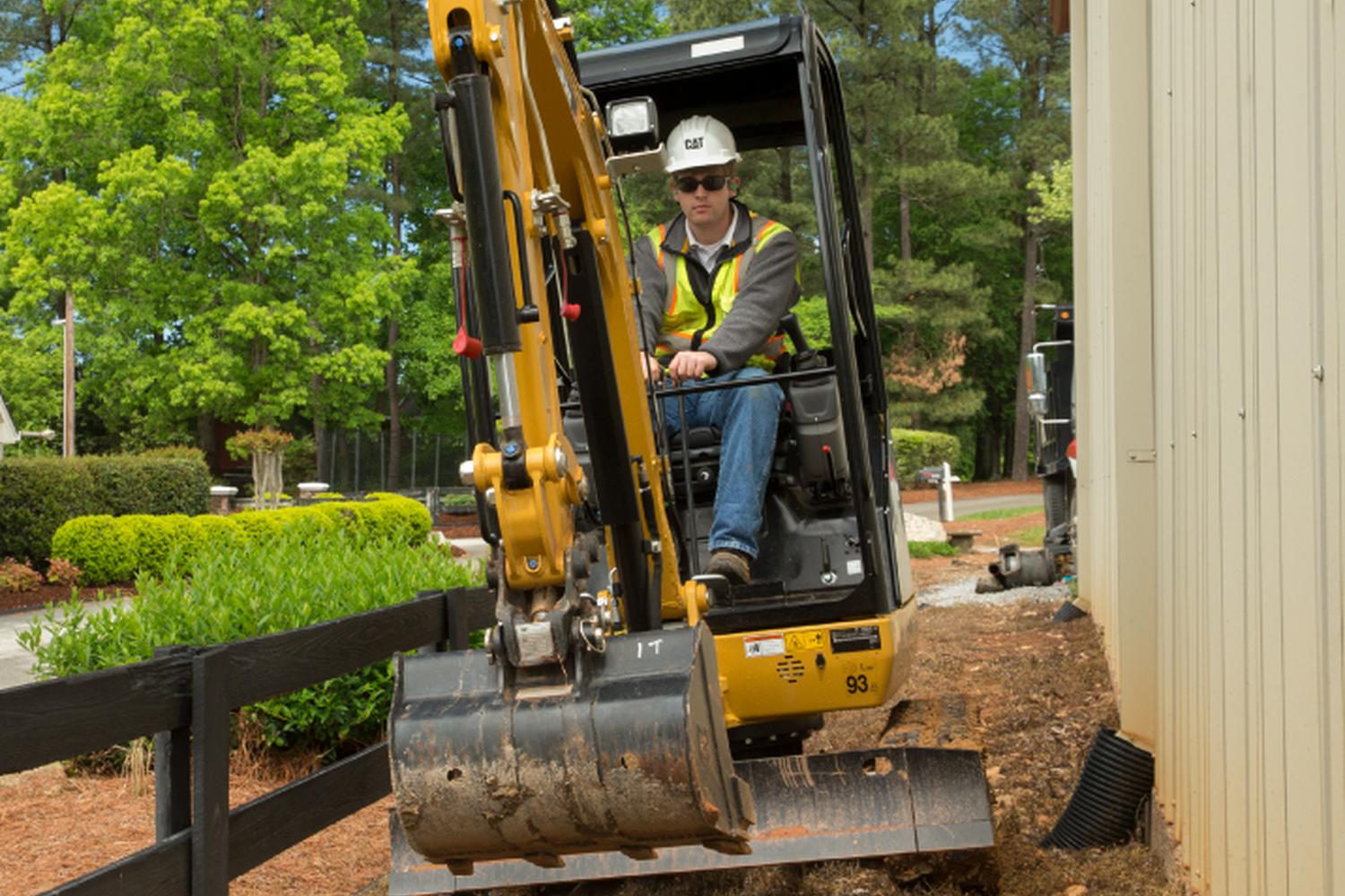 mini-exacavator-doing-suburban-landscaping-article-article Small CAT excavator working on a suburban landscaping project